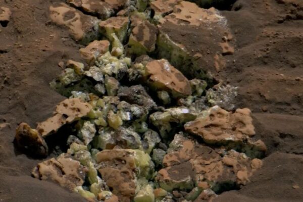 A photo showing a pile of rocks with yellow crystals inside