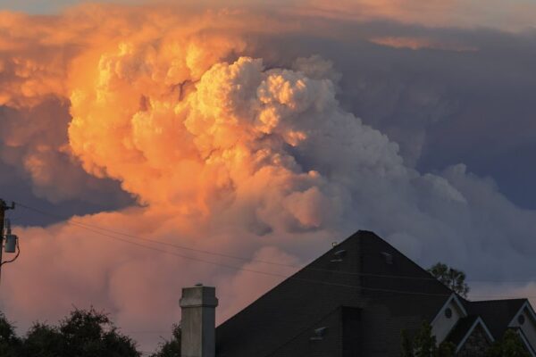 A cloud of smoke behind a suburban house