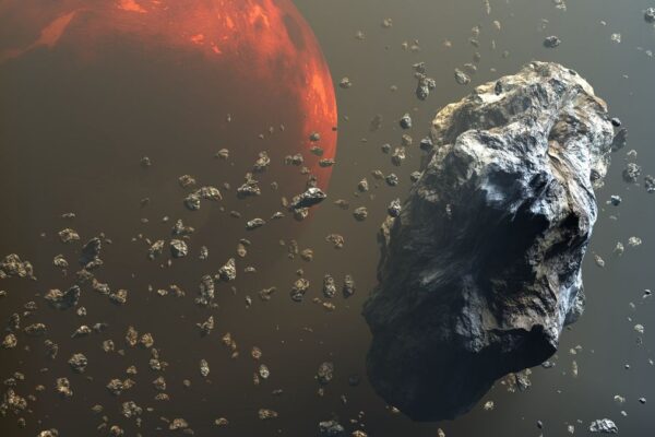 craggy grey rocks float above a reddish orange planet