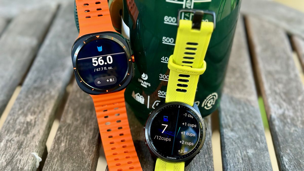 The Garmin Forerunner 965 and Samsung Galaxy Watch Ultra sitting in front of a bottle of water, both showing their respective hydration apps.