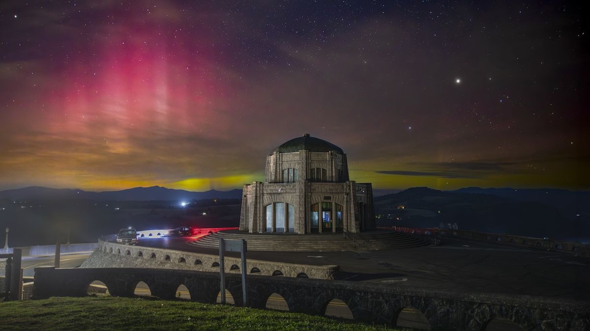 Auroras behind a domed building on a hill