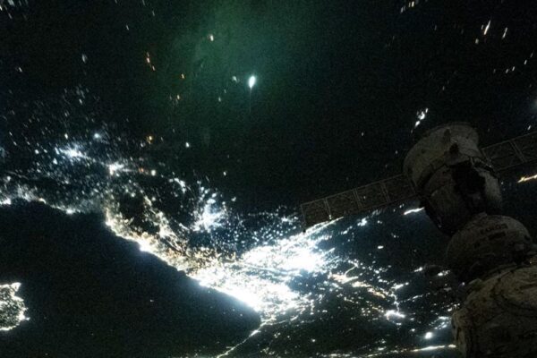 a bright green streak can be seen above earth as seen from space