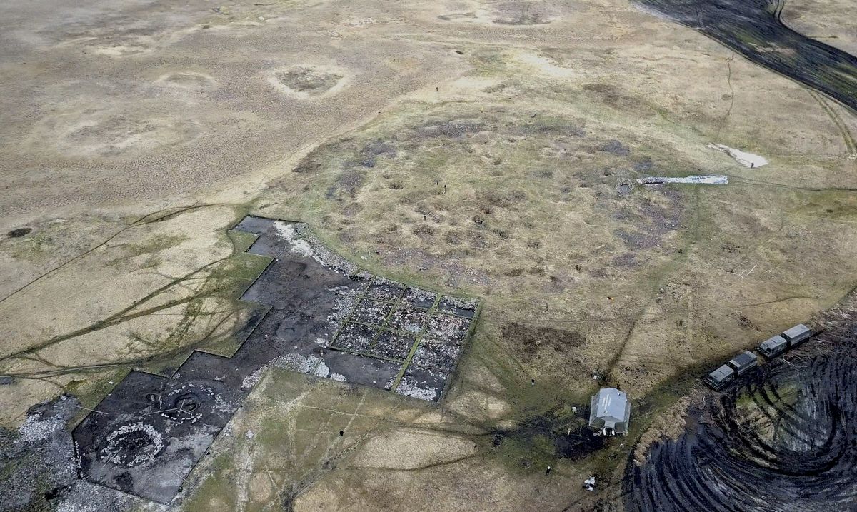 An arial shot of a round divot in a grassy plan, surrounded by excavation quadrants.