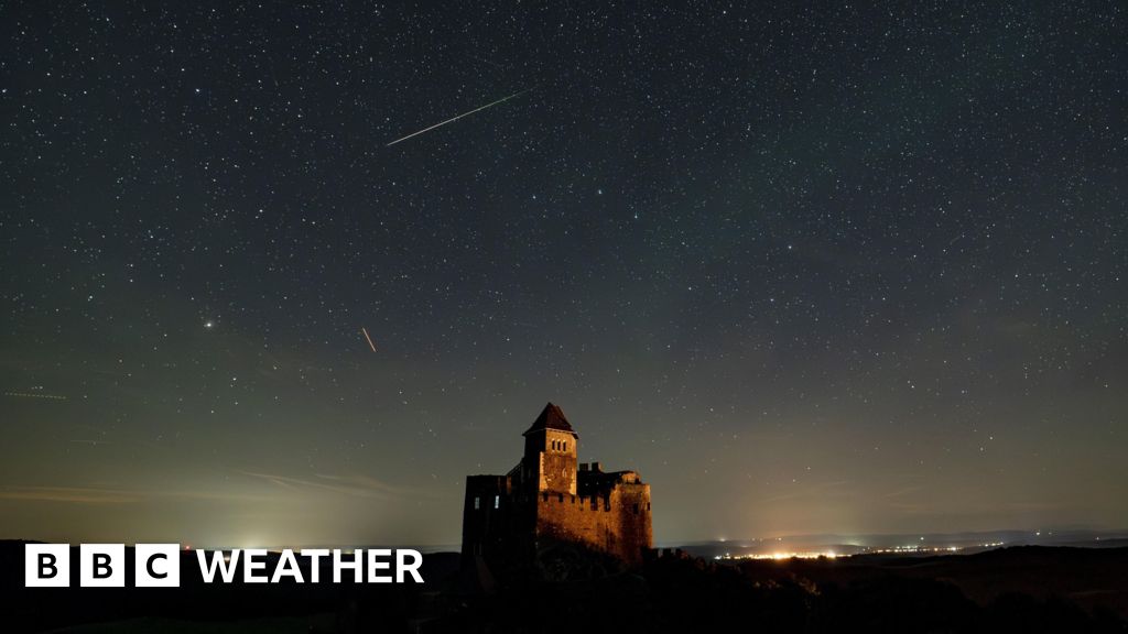 A castle and the night sky showing stars and a meteor