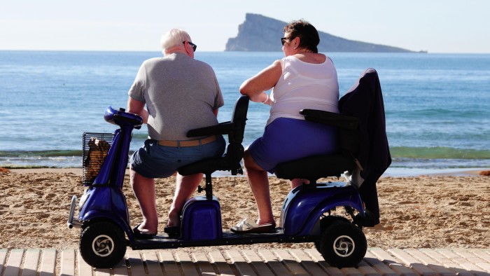 Elderly British tourists relaxing on the beach in Spain