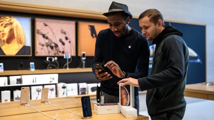 A customer purchases iPhones at the Apple Regent Street store in London